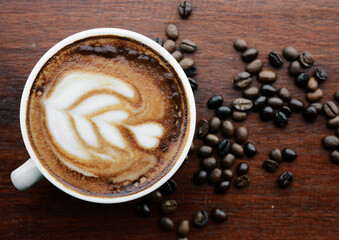 coffee cup and coffee beans on wooden table