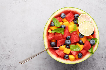 Fruit salad in half of watermelon. Peach, blueberry and juicy pieces of watermelon with mint....