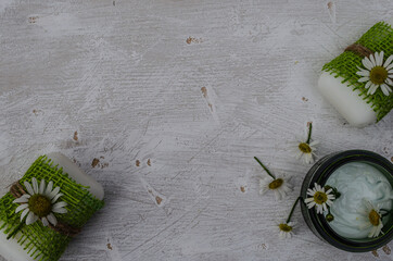 Cream, handmade soap, chamomile flowers on a white background. Organic cosmetics based on chamomile extract. Place for signature.