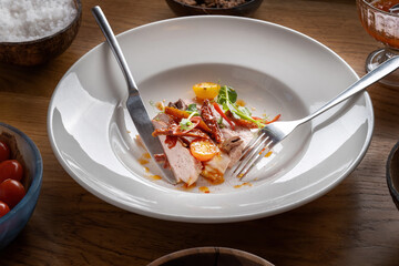 Roasted Duck Meat with Tomatoes, Small Green Sprouts and Sauce.