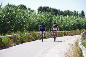 jeunes garçons cyclistes à vélo, sur piste cyclable voie verte 