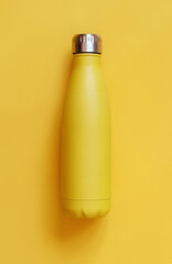 Close-up of yellow reusable steel bottle on yellow background