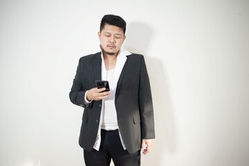 Asian businessman wearing a suit And white shirt Is using a smartphone