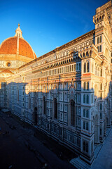 Aerial, vertical view of Cathedral of Saint Mary of the Flower in Florence.   Gothic dome and street, illuminated by red light of setting sun. UNESCO World Heritage Site, Florence, Italy.