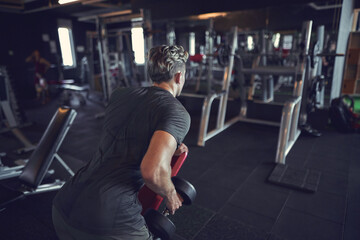 young guy bodybuilder works out in the gym    