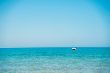 Bellissimo paesaggio marino con barca a vela all'orizzonte.