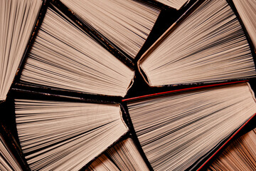 Open multi-colored old books stand on a bookshelf in the home library