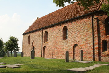 Fototapeta premium Ezinge-August-16-2020. The Church of Ezinge and gravestones from the 13th century in Ezinge. The Netherlands