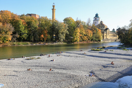 München: Blick vom renaturierten Fluss Isar Strand auf das Müllersche Volksbad und das Kulturzentrum Gasteig im Herbst