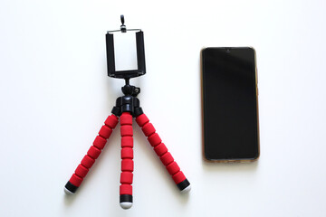 Mobile phone and tripod on white background.Smart phone new technology dedicated for live streaming. Blogger equipment.