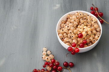 red and white currants on a dark background. white Cup with white currants. the view from the top. place to copy
