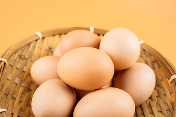 Eggs in a bamboo basket on yellow background