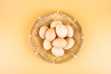 Eggs in a bamboo basket on yellow background