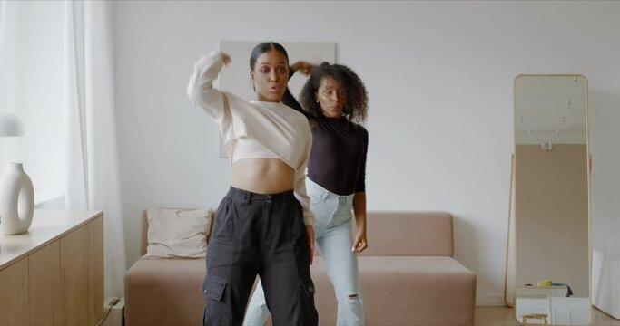 Two African-American Black girls recording trendy dance moves for social media account