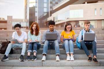 Students Learning Preparing For End-Of-Semester Exams Sitting On Steps Outside