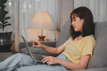 Asian businesswoman working online alone at home. Woman lifestyle in living room. Social distancing...