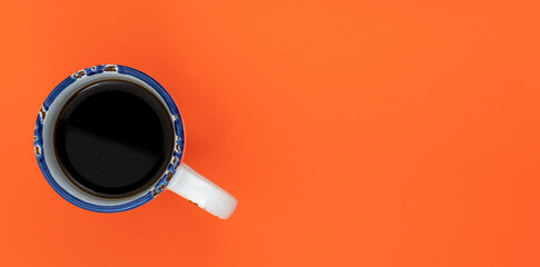 Top view, flat lay of black coffee cup on background orange.