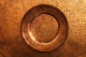 Empty plate on brass background. Top view with clipping path