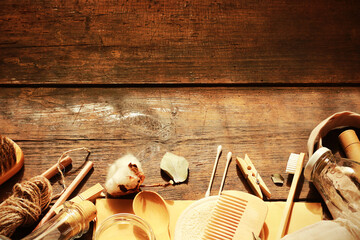 Zero waste concept Eco-friendly  bath  accessories and kitchen utensils Craft paper bag, glass jars, bamboo toothbrushes, hairbrush  on  wooden background Recycling  Creative flat lay with copy space