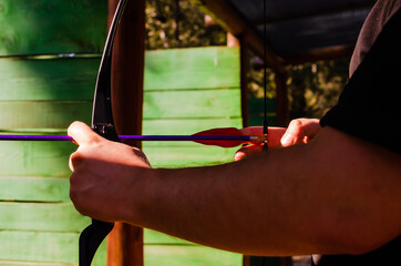 Archery range with man holding a bow and a green background