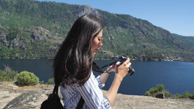 elegant young female asian photographer love wild freedom lifestyle travel in nature mountains lakes taking picture of amazing view in o shaughnessy dam. girl backpacker in sunglasses photographing.