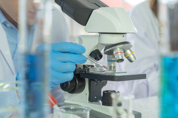 Scientist working on colorful test tube to analysis and develop vaccine of covid-19 virus in lab or...
