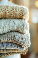 Closeup on young woman holding sweaters