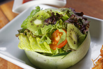Grilled shrimp breaded with coconut and served over sweet and sour sauce and accompanied by lettuce, cucumber, tomato and kiwi salad.