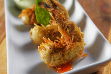 Grilled shrimp breaded with coconut and served over sweet and sour sauce and accompanied by lettuce, cucumber, tomato and kiwi salad.