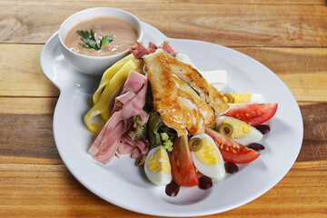 Barbecued chicken fajitas served on lettuce leaves with Manchego cheese, ham, black olive, green olive, tomato, hard-boiled egg, garlic and cheese dressing.