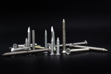 Screws and nails on a black background