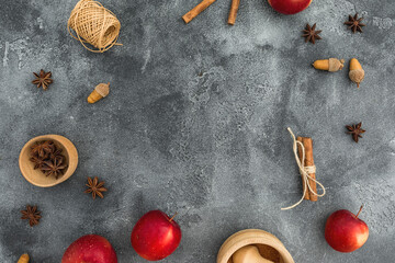 Autumnal composition with copy space. Fall leaves, apple, cinnamon and acorns on dark. Thanksgiving day concept. Flat lay