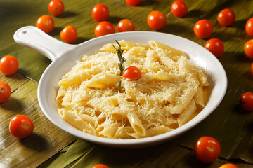 Bucatini pasta in garlic sauce, Parmesan cheese and cherry tomato.