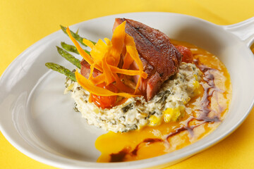 Roasted pork fillet with potato and corn salad accompanied by asparagus and cherry tomato.