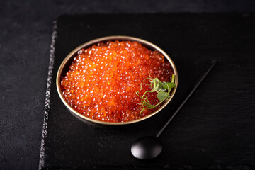 red large salted caviar in a small black plate