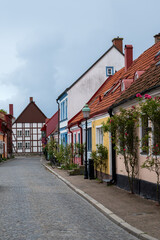 An empty cozy cobblestoned street with multi colored town houses and cottages in the village of Ystad, Sweden