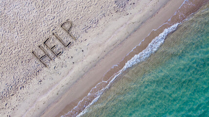 Help written on exotic sand beach with tropic blue sea. 