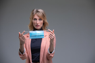 Blond woman hold her surgical mask