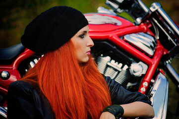 Obraz na płótnie Canvas red-haired beautiful girl and motorcycle outdoors