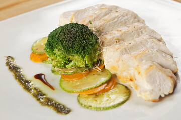 Grilled chicken breast with pumpkin, carrot and broccoli, garnished with chimichurri.