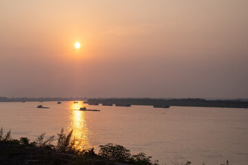 Naklejka premium Sunset over the red river with boats in hanoi