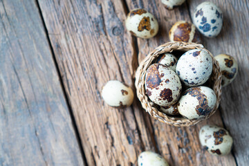 Fototapeta premium Quail eggs in a little wicker basket. Top view. Copy space.