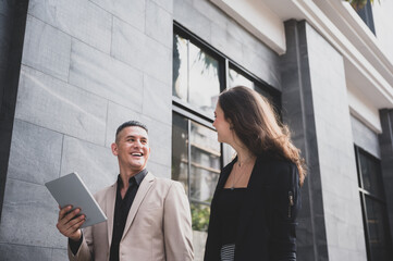 Business people discussing and smiling while walking together outdoor
