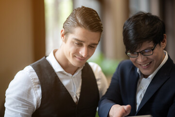 business men in suits discussing or planning business issues in the office. Colleagues or client and consultant are sitting at the table next to each other and talking