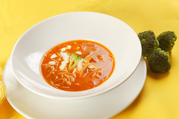 Noodle soup with chicken and tomato.