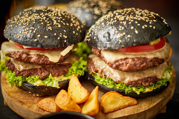 Appetizing black hamburgers and fried potato
