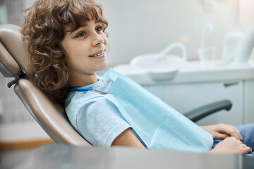 Cheerful child in a dental chair waiting for a dentist