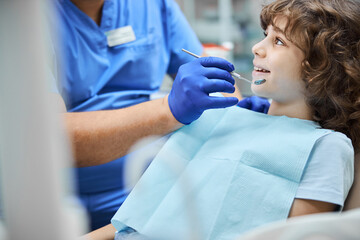 Fototapeta premium Cheerful kid smiling during a dental check-up