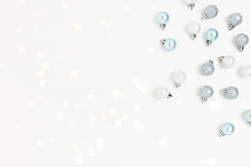 Silver Christmas balls on a white background. Minimalistic shiny festive concept with copy space.