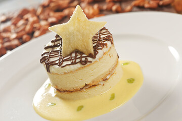 Vanilla dessert with custard, chocolate and star-shaped biscuit.